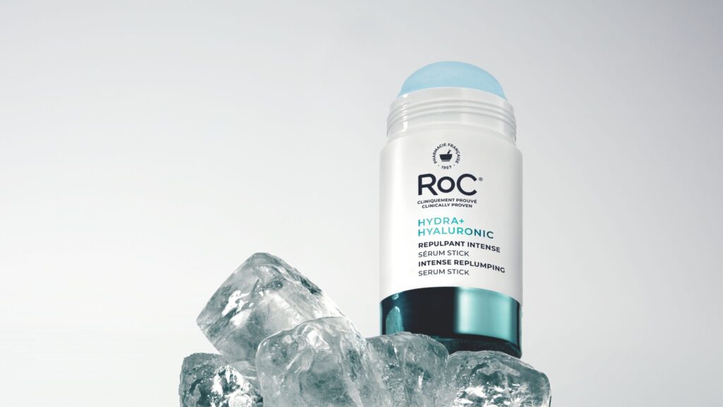 Barra de sérum con ácido hialurónico de RoC colocada sobre cubos de hielo transparentes.