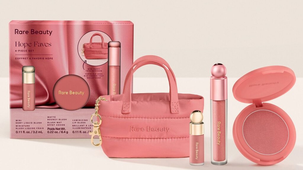 Set de maquillaje en tonos rosa de Rare Beauty junto al bolso miniatura acolchado rosa.